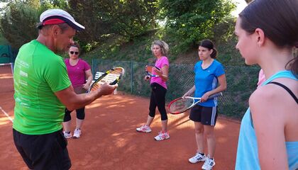 Ein Tennislehrer erklärt etwas