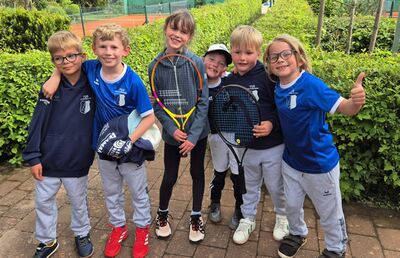 Kinder mit Tennisschläger in der Hand und Daumen hoch