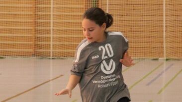 Jugendhandball Spielerin beim Dribbling mit dem Ball in der Sporthalle, dynamische Spielszene im Nachwuchs-Handballverein
